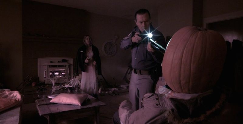 scene from helliosn with gun pointed at pumpkin
