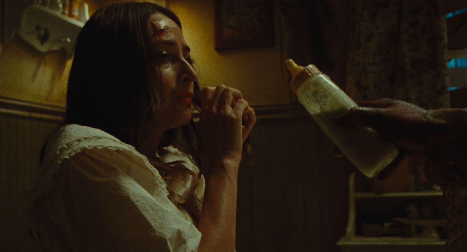 Macy is handed a bottle from someone offscreen