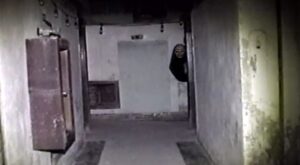 The demon in Parasomnia (2026) peeking around a corner