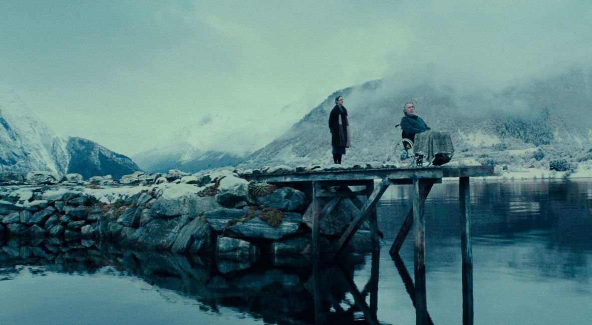 Two characters stand on a snowy pier