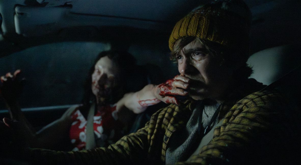 Bryan sits in a car with an undead creature