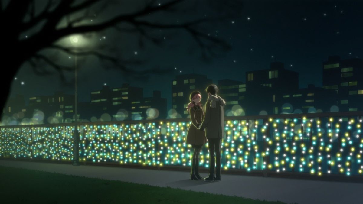 Suzuki and Tani stand together at night against the city